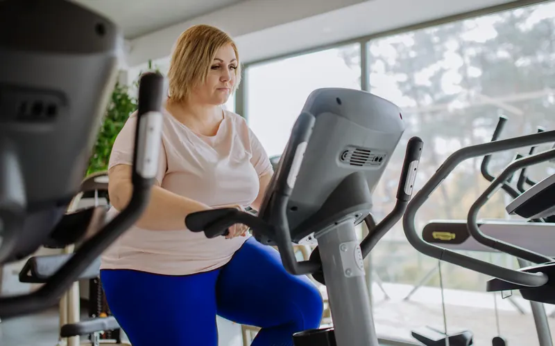 Woman riding an exercise bike at the gym
