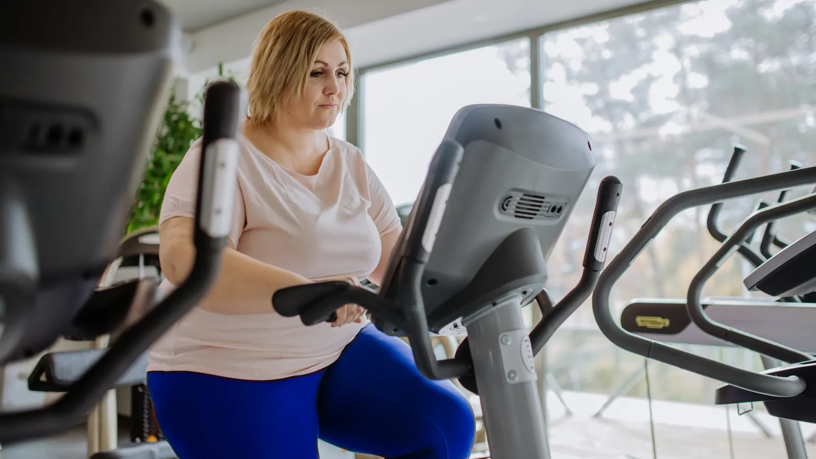 Woman riding an exercise bike at the gym