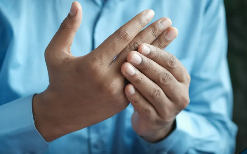 Person rubbing a sore, stiff hand