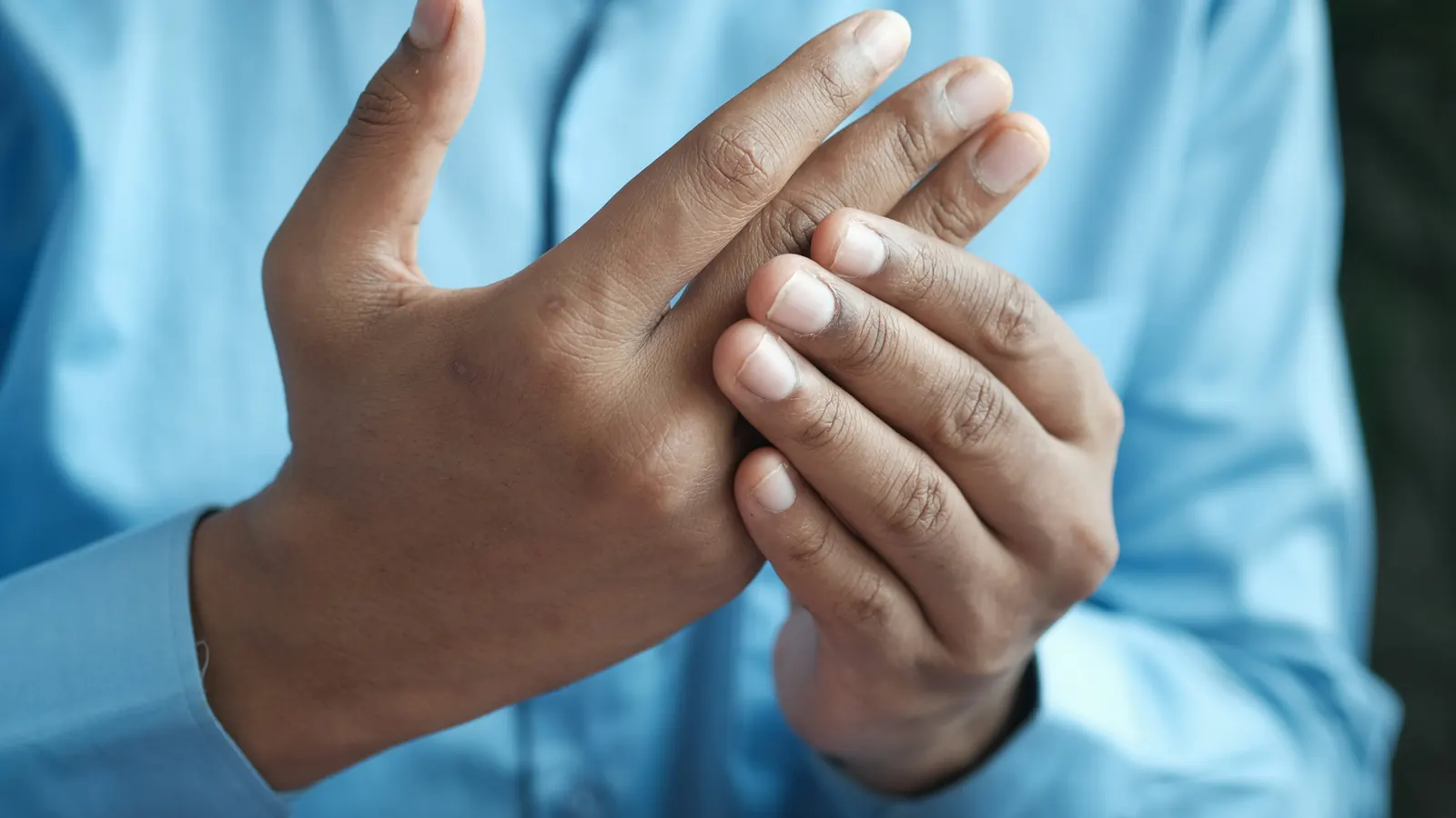 Person rubbing a sore, stiff hand