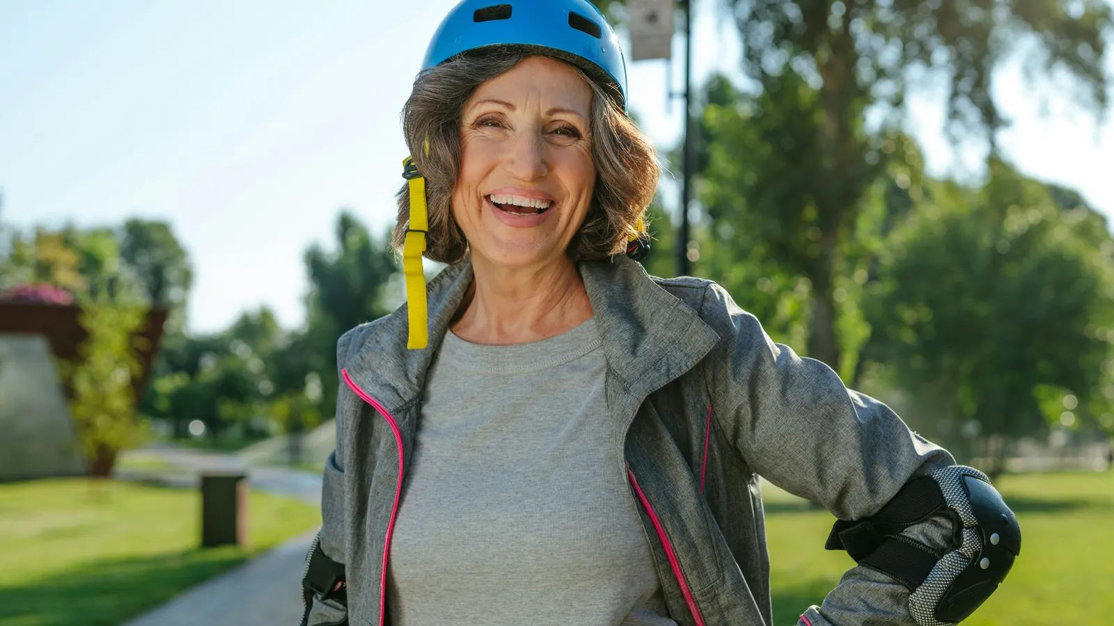 Smiling older woman in a bike helmet outdoors