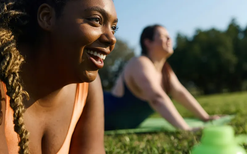 Woman relaxing on the grass outdoors with a water bottle